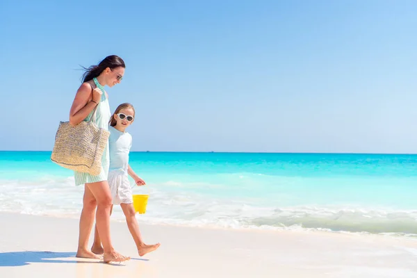 Liten bedårande flicka och ung mor på tropisk strand — Stockfoto