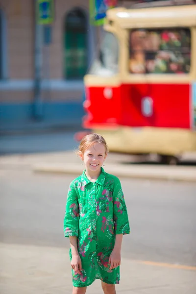 Entzückend glückliches kleines Mädchen im Freien in der europäischen Stadt. — Stockfoto