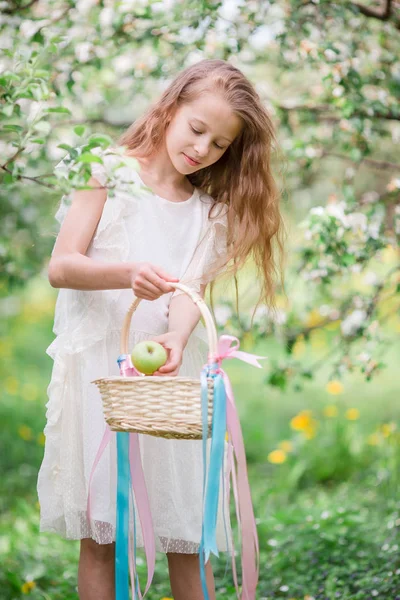 Liebenswertes kleines Mädchen im blühenden Apfelgarten an einem schönen Frühlingstag — Stockfoto
