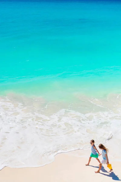 Adorable little girls have a lot of fun on the beach. — Stock Photo, Image