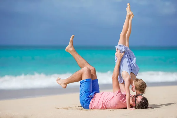 Семья отца и спортивная маленькая девочка веселятся на пляже — стоковое фото