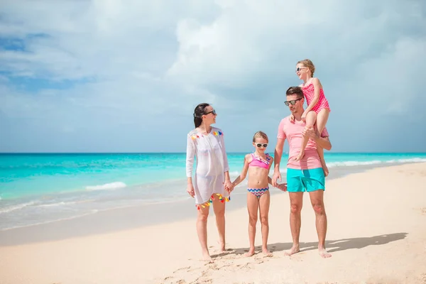 Familia joven de vacaciones en la playa. — Foto de Stock