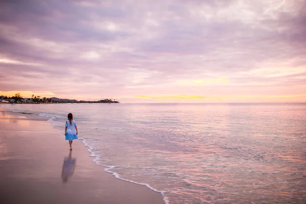 Gün batımında sahilde dans küçük kız Sihouette.