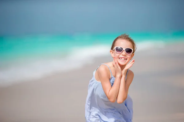 Vacker liten flicka i klänning på beach har kul. — Stockfoto