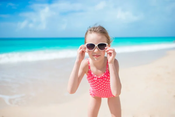 Schöne kleine Mädchen im Kleid am Strand Spaß haben. — Stockfoto