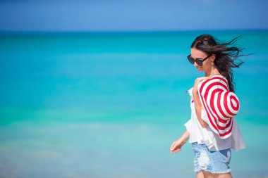 Genç ve güzel bir kadın tropik deniz kıyısında eğleniyor..