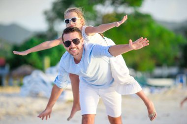 Küçük kız ve mutlu baba kumsal tatili boyunca eğleniyorlar.