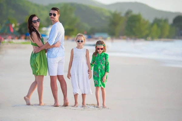 Family of four walking on white beach — Stock Photo, Image