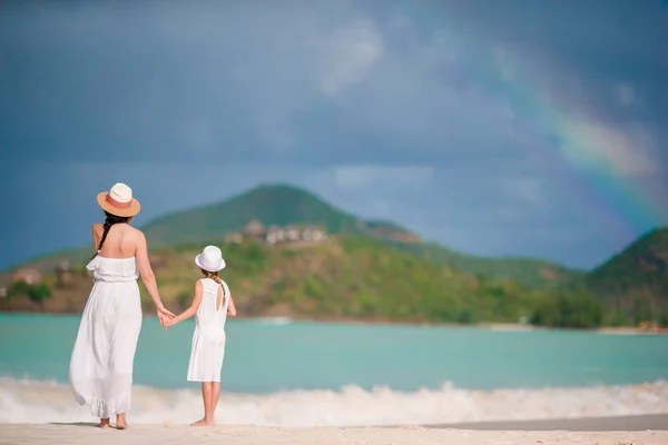 Junge schöne Mutter und ihre entzückende kleine Tochter haben Spaß am tropischen Strand — Stockfoto