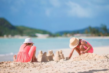 Çok güzel küçük çocuklar beyaz sahilde kum ile oynamak