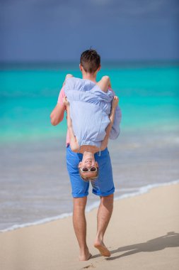 Küçük kız ve mutlu baba kumsal tatili boyunca eğleniyorlar.