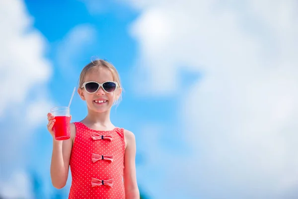 Roztomilá holčička pít koktejl na tropické pláži — Stock fotografie