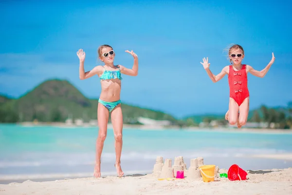 两个孩子正在做沙堡，在热带海滩玩得很开心 — 图库照片