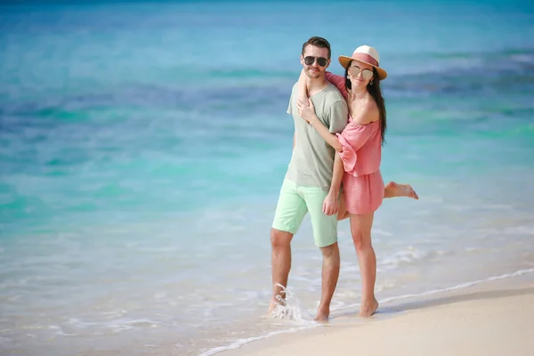 Νεαρό ζευγάρι στην παραλία με λευκή κατά τη διάρκεια των θερινών διακοπών. Ευτυχισμένη οικογένεια να απολαύσετε το γαμήλιο ταξίδι τους — Φωτογραφία Αρχείου