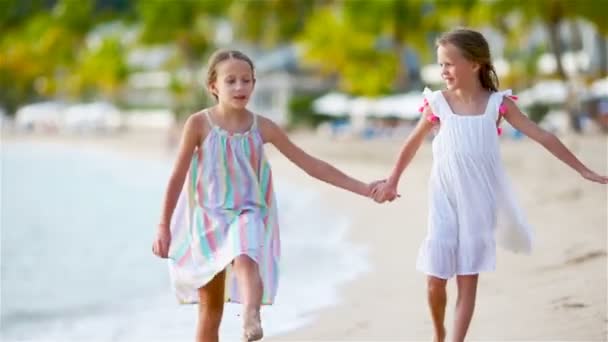 Twee kleine gelukkige meisjes hebben veel plezier op tropische strand spelen samen — Stockvideo