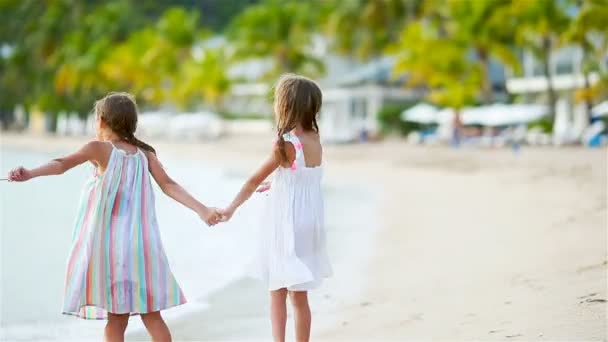 İki küçük mutlu kız tropikal plajda birlikte oynarken çok eğleniyor. — Stok video