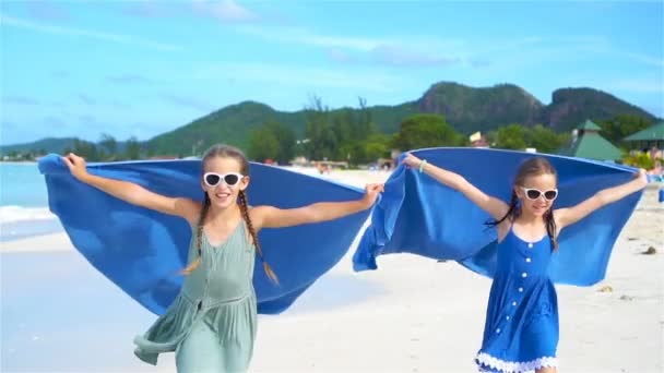 Little girls have fun with beach towel during tropical vacation — Stock Video