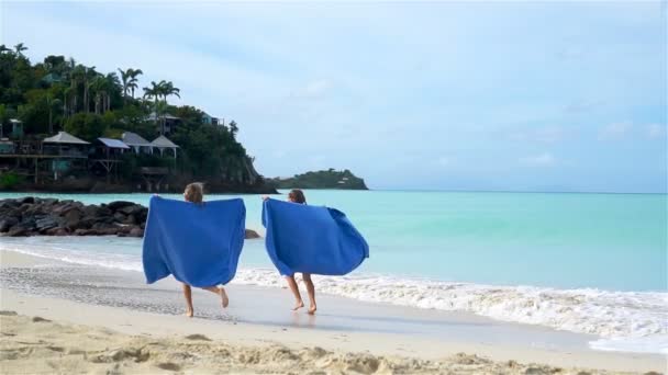 Niñas se divierten con toalla de playa durante las vacaciones tropicales — Vídeo de stock