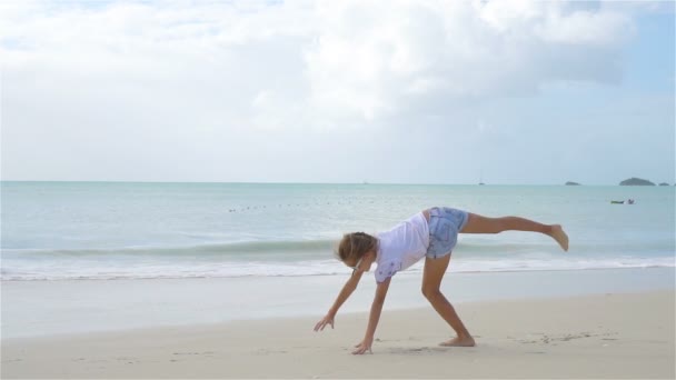 Underbar aktiv liten flicka på stranden under sommarlovet — Stockvideo