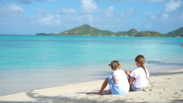 Dos niñas felices se divierten mucho en la playa tropical jugando juntas con arena — Vídeos de Stock