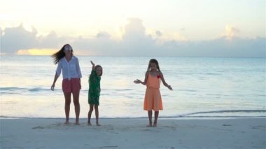 Güzel anne ve sevimli küçük kızları sahilde