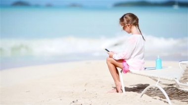 Küçük kız yapma video veya şezlong üzerinde oturan onun kamera ile fotoğraf