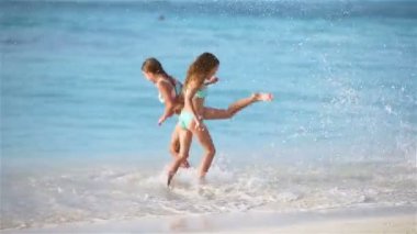 Küçük mutlu çocuklar birlikte oynayan tropikal kumsalda eğlenmeye var