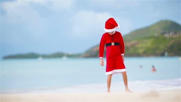 Little girl in Christmas hat on white beach during Xmas vacation — Stock Video