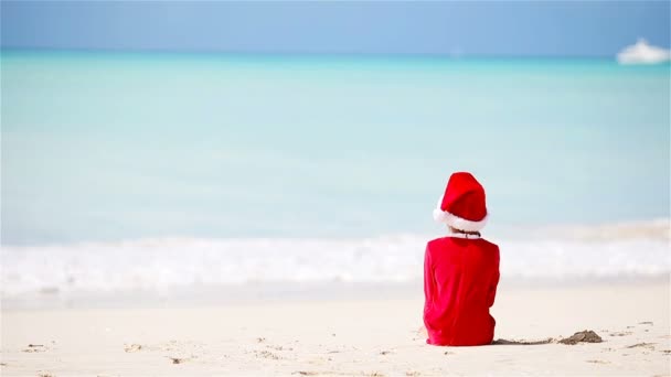 Klein meisje in KERSTMUTS op witte strand tijdens kerst vakantie — Stockvideo