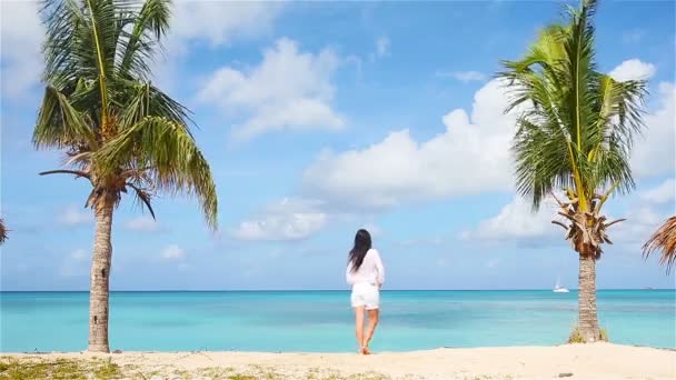 Jovem mulher bonita na costa tropical. Menina feliz relaxante na areia branca praia tropical — Vídeo de Stock
