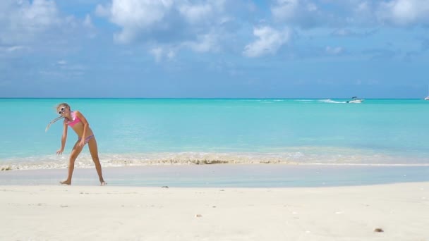 Живая активная девочка на пляже во время летних каникул — стоковое видео
