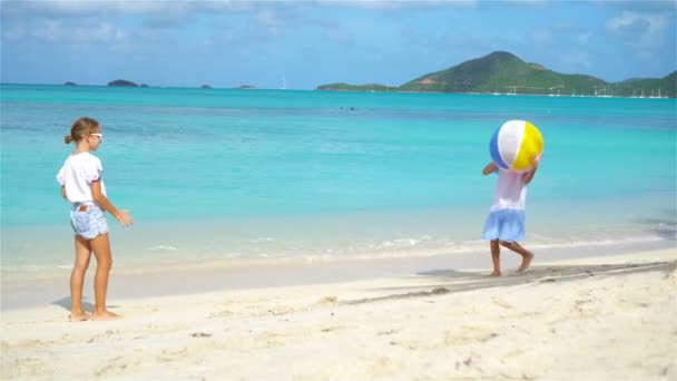 Pequenas garotas adoráveis brincando com bola na praia — Vídeo de Stock