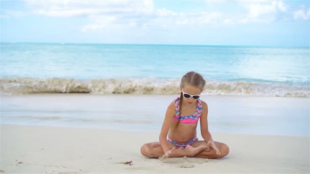 Imádnivaló aktív kislány hófehér homokos strandon — Stock videók