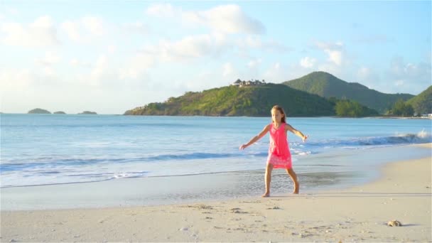 Sihouette küçük kızın batımında sahilde yürüyüş. — Stok video