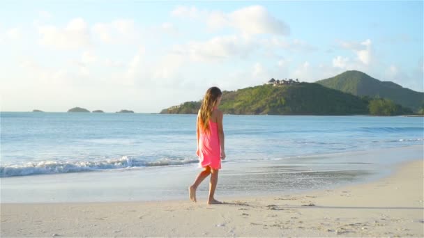 Sihouette de niña caminando en la playa al atardecer . — Vídeos de Stock