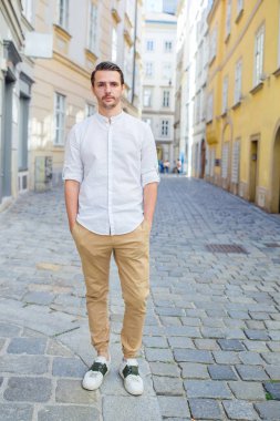 Genç adam eski Avrupa şehrinin özçekimini yapıyor.