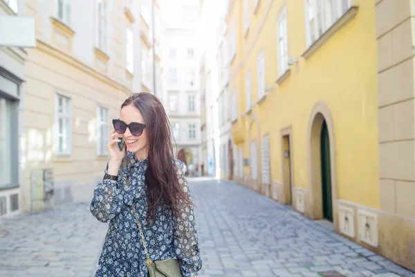 Woman talk by her smartphone in city. Young attractive tourist outdoors in italian city — Stock Photo, Image