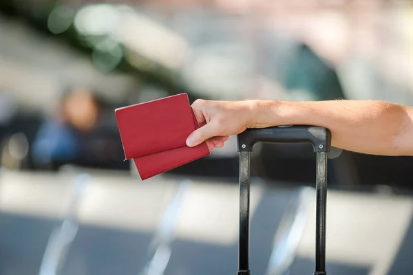 Closeup of man holding passports and boarding pass at airport — Stock Photo, Image