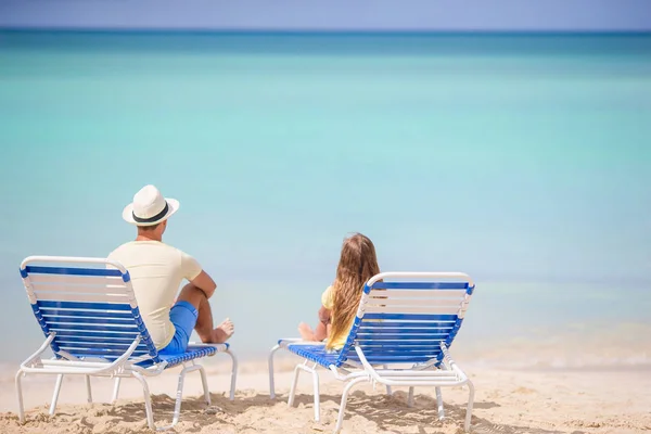 Padre e hija en la playa sentados en chaise-longue — Foto de Stock