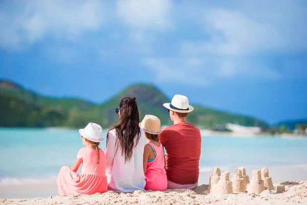 Family of four making sand castle at tropica beach — Stock Photo, Image