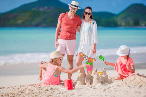 Famiglia che fa castello di sabbia sulla spiaggia bianca durante le vacanze estive — Foto Stock