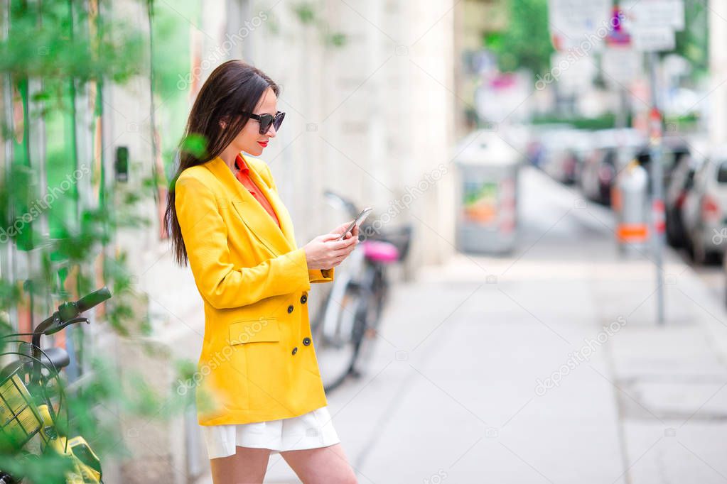 Woman talk by her smartphone in city. Young attractive tourist outdoors in italian city