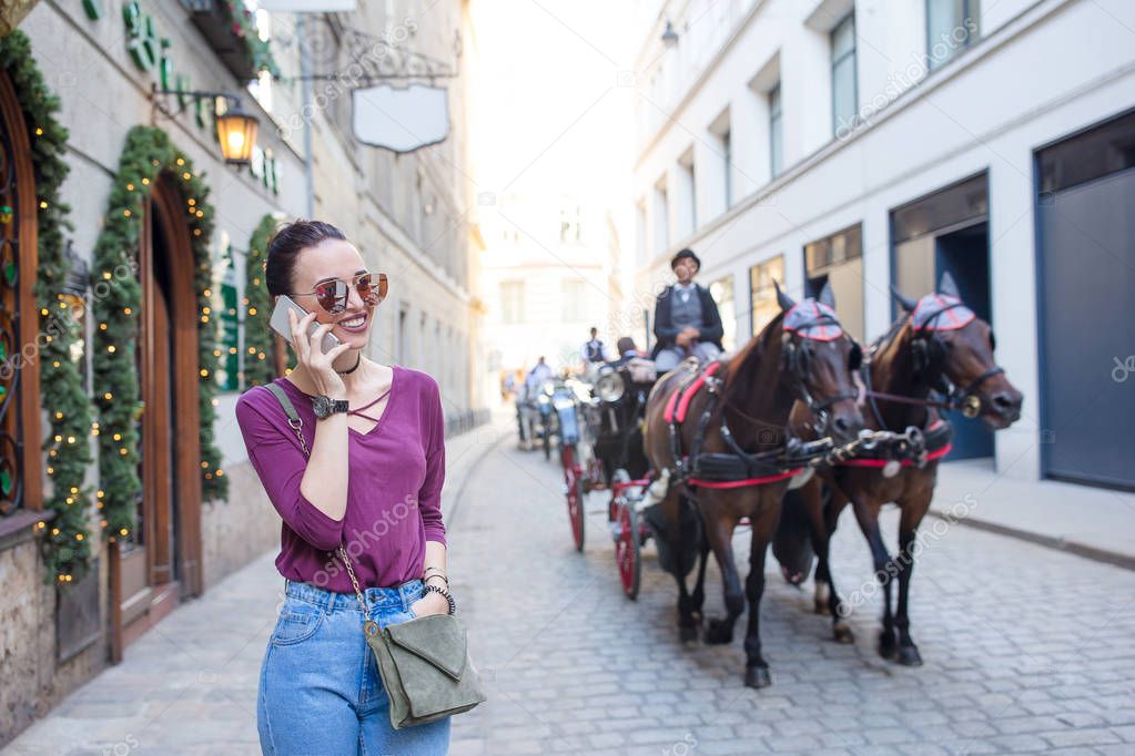 Woman talk by her smartphone in city. Young attractive tourist outdoors in italian city