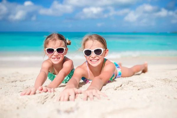 Šťastné děti ležící na teplé bílé písečné pláži — Stock fotografie