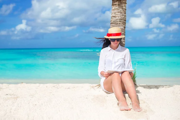 Joven mujer leyendo libro durante tropical blanco playa —  Fotos de Stock