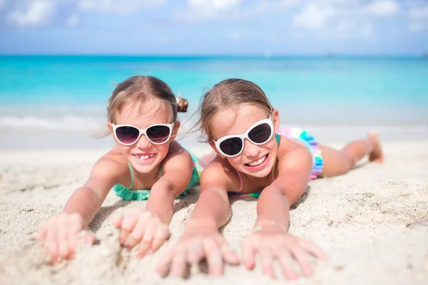 在沙滩上关闭小女孩。快乐的孩子躺在温暖的白色沙滩上 — 图库照片