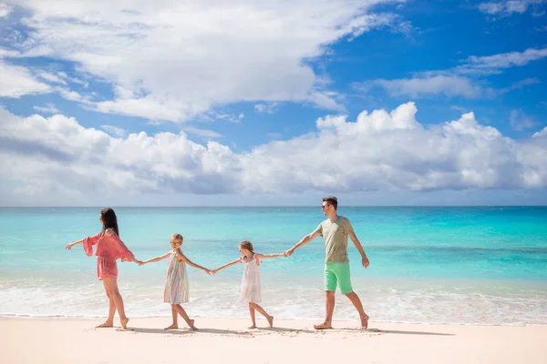 Familj på fyra promenader på vit strand — Stockfoto