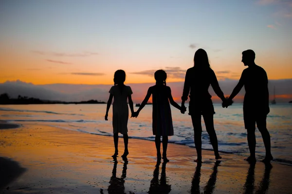 ビーチで夕日に家族のシルエット — ストック写真