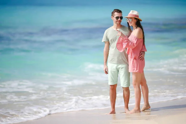 Молодая пара на белом пляже во время летних каникул. Счастливая семья наслаждается своим медовым месяцем — стоковое фото