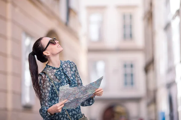 Mujer joven con un mapa de la ciudad. Viajar chica turística con mapa en Viena al aire libre durante las vacaciones en Europa . — Foto de Stock